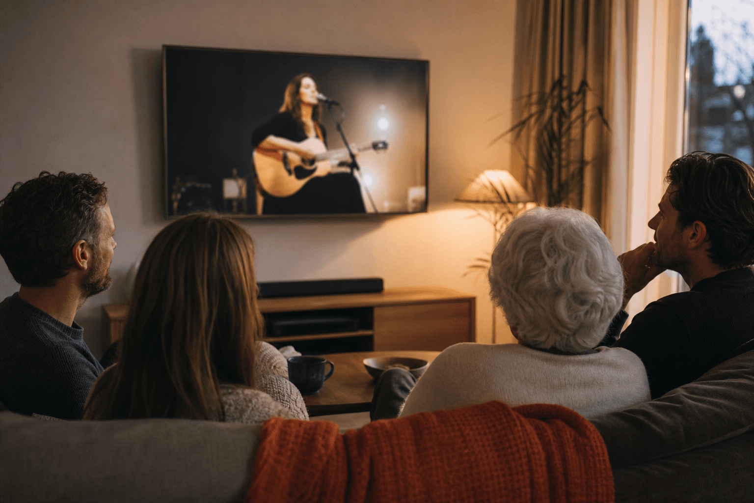 Een familie beleeft samen een muzikaal live optreden op televisie