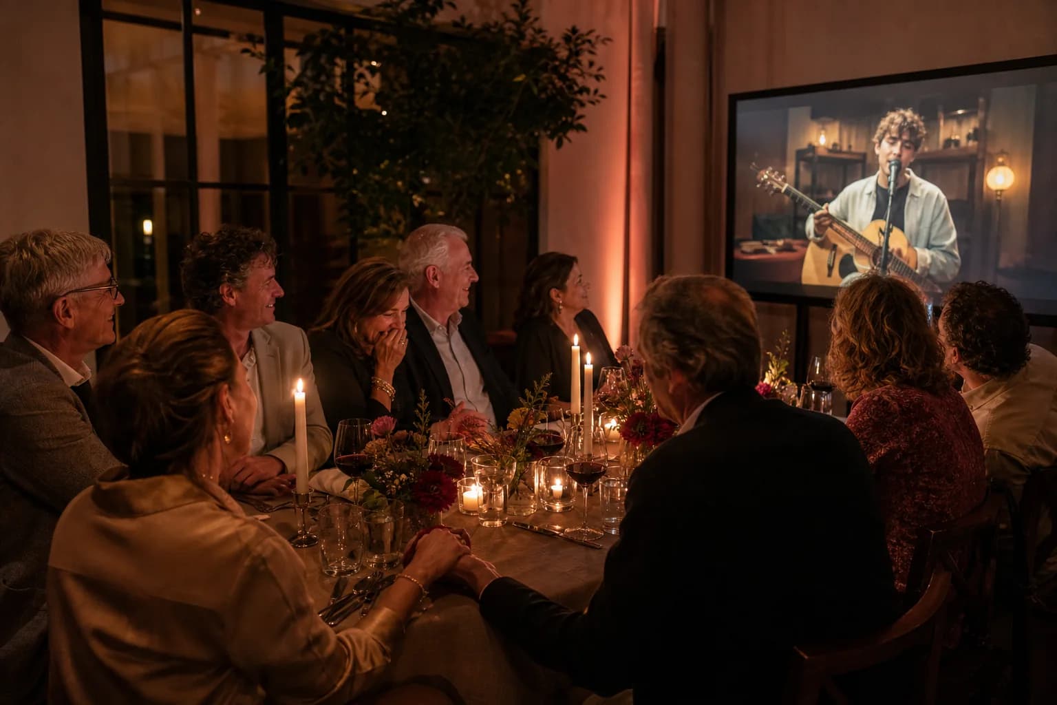 Familie en vrienden beleven samen een persoonlijke live serenade tijdens een jubileumdiner